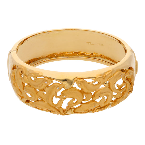 Brazalete ovalado articulado firma Carrera y Carrera motivo delfines con diamantes en oro amarillo 18 kilates.