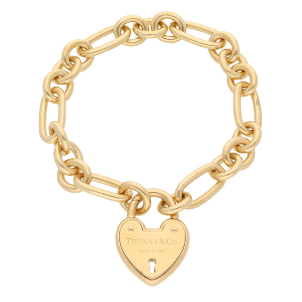 Pulsera eslabón combinado con dije motivo candado de corazón firma Tiffany & Co. en oro amarillo 18 kilates.