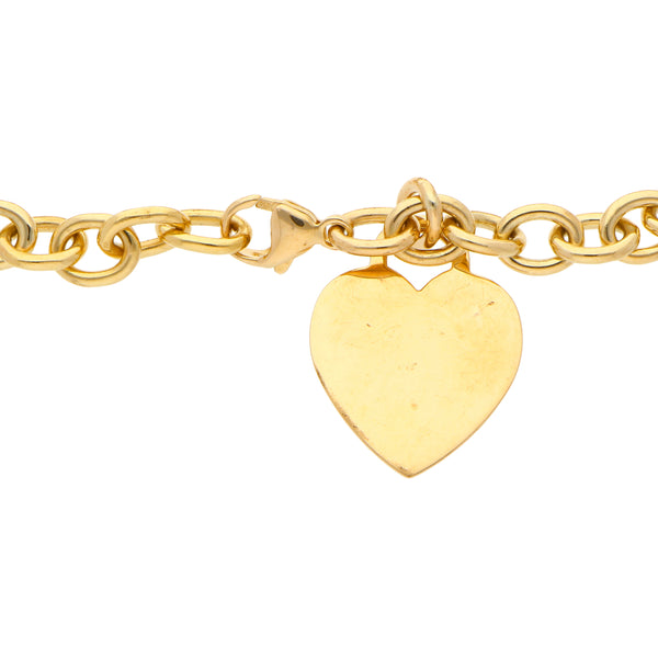 Pulsera eslabón cruzado con pendiente motivo corazón firma Tiffany & Co. en oro amarillo 18 kilates.