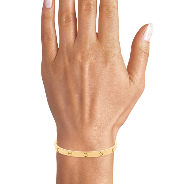 Brazalete rígido articulado motivo tornillos simulados firma Cartier en oro amarillo 18 kilates.