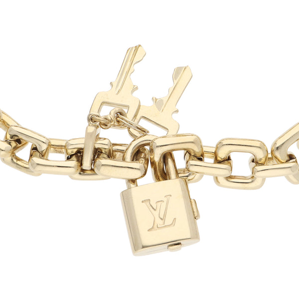 Pulsera hechura especial con broche motivo candado y pendiente motivo llave firma LV en oro amarillo 18 kilates.