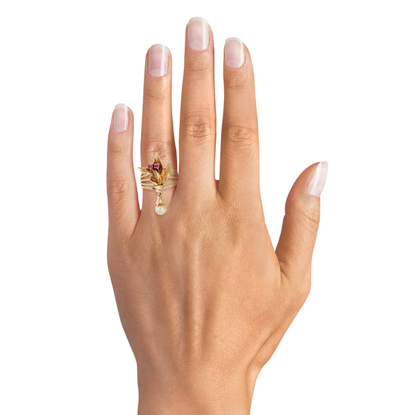 Anillo calado motivo floral con perla y rubíes en oro amarillo 18 kilates.