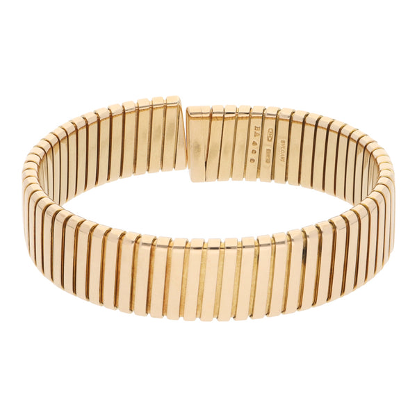 Brazalete abierto acanalado firma Bvlgari en oro amarillo 18 kilates.