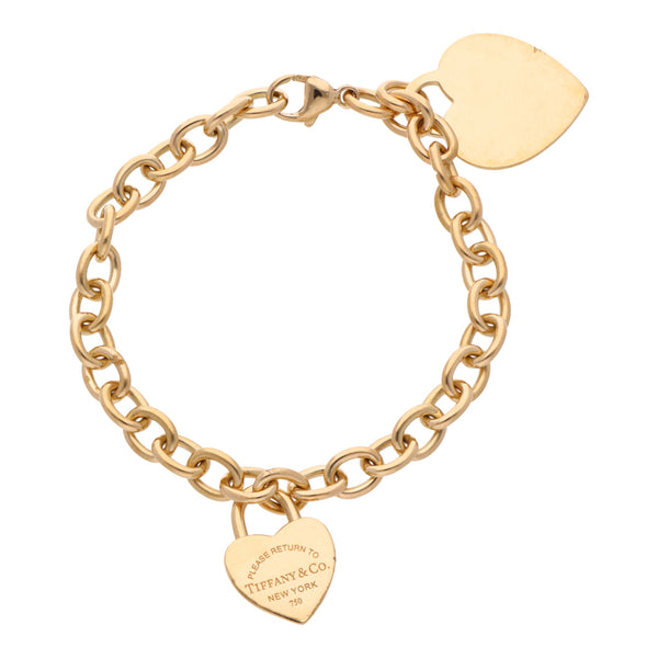 Pulsera eslabón cruzado firma Tiffany & Co. con dos pendientes motivo corazón en oro amarillo 18 kilates.