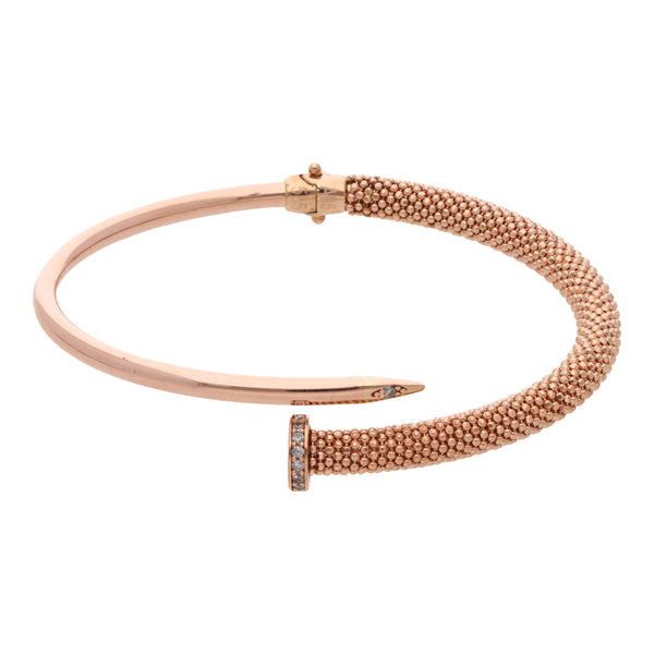 Pulsera abierta articulada motivo clavo con sintéticos en oro rosa 14 kilates.