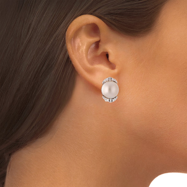 Aretes hechura especial con medias perlas y diamantes en oro blanco 14 kilates.