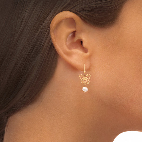 Aretes calados motivo mariposa con perlas en oro amarillo 14 kilates.