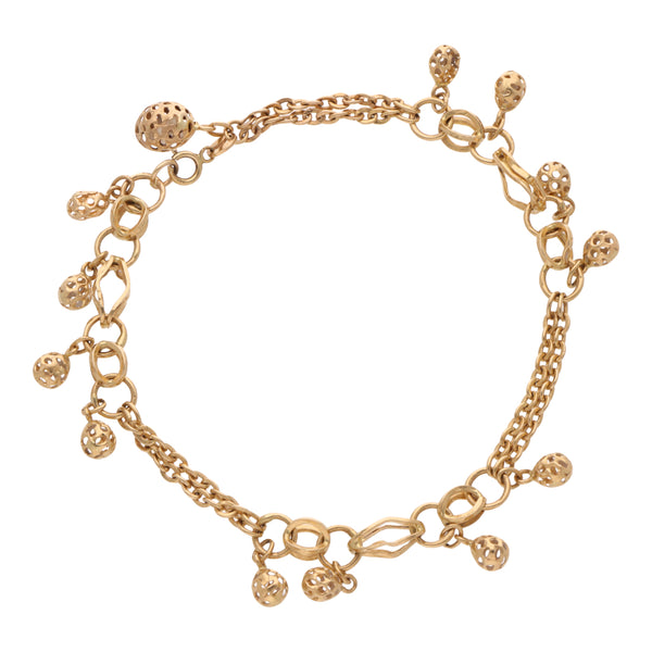 Pulsera eslabón combinado con esferas caladas en oro amarillo 14 kilates.