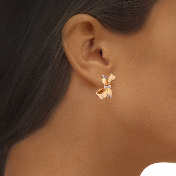 Aretes estilizados con diamantes motivo moño en oro dos tonos 18 kilates.