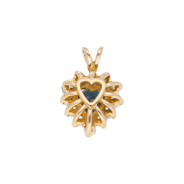 Dije diseño especial motivo corazón con zafiro y diamantes en oro amarillo 14 kilates.