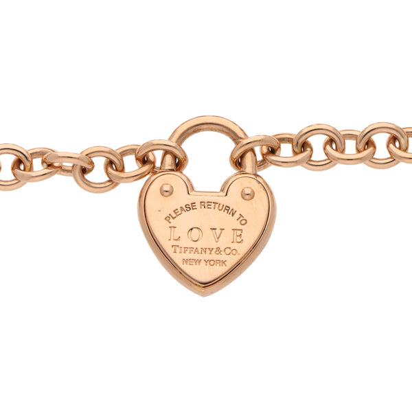 Pulsera eslabón cruzado con dije motivo corazón firma Tiffany & Co. en oro rosa 18 kilates.