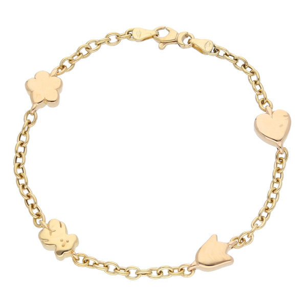 Pulsera eslabón cruzado con cuatro dijes motivo oso, corazón y flores en oro amarillo 18 kilates.