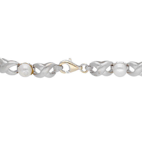 Pulsera estilizada con perlas en oro blanco 14 kilates.