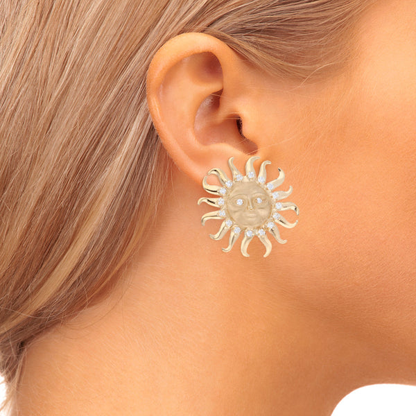 Aretes estilizados motivo sol con circonias en oro amarillo 14 kilates.