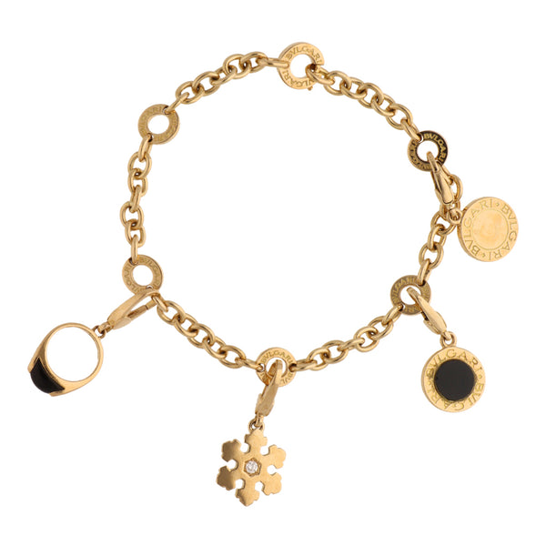 Pulsera eslabón cruzado firma Bvlgari con dijes, ónix y diamante en oro amarillo 18 kilates.