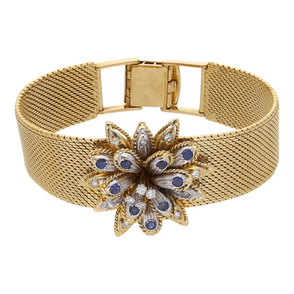 Pulsera eslabón tejido motivo flor con diamantes y zafiros en oro dos tonos 18 kilates.