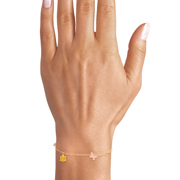 Pulsera eslabón cruzado con cinco dijes con esmalte en oro amarillo 18 kilates.