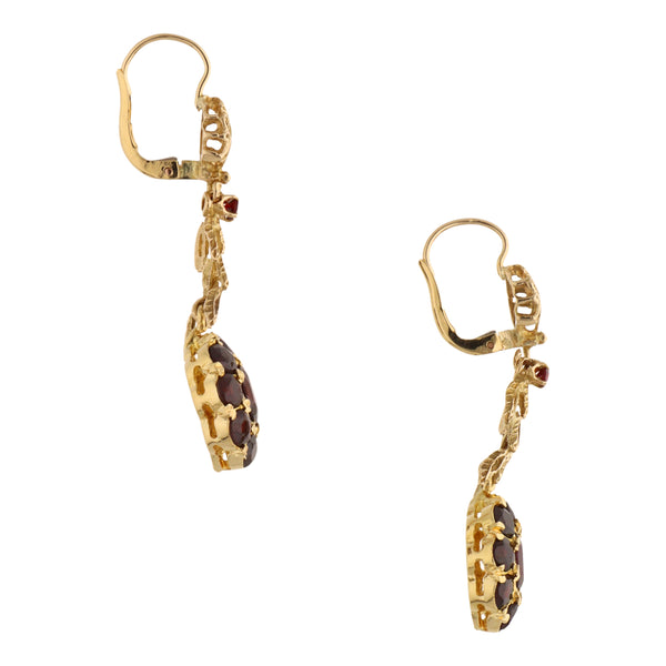 Aretes calados con colgantes y granates en oro amarillo 18 kilates.