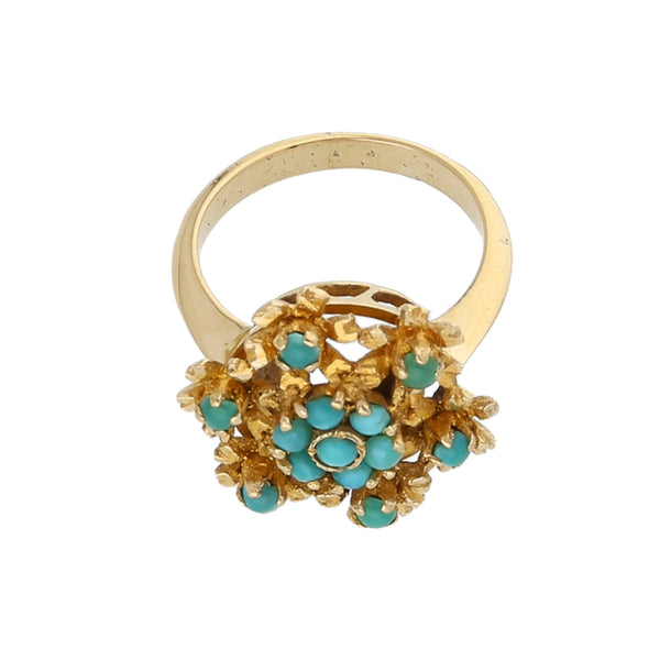 Anillo calado motivo floral con turquesas en oro amarillo 18 kilates.