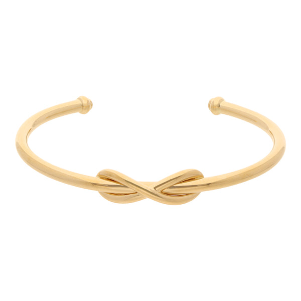 Pulsera abierta tubular motivo infinito firma Tiffany & Co. en oro amarillo 18 kilates.