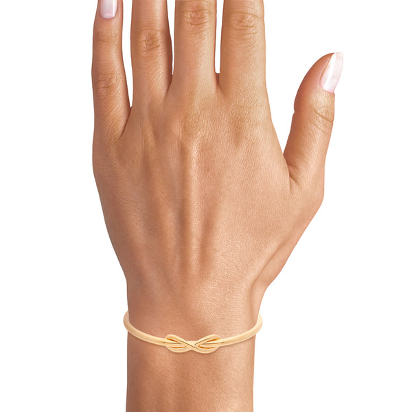 Pulsera abierta tubular motivo infinito firma Tiffany & Co. en oro amarillo 18 kilates.