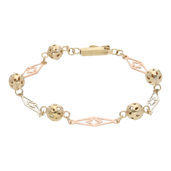 Pulsera eslabón combinado con esferas caladas en oro tres tonos 14 kilates.