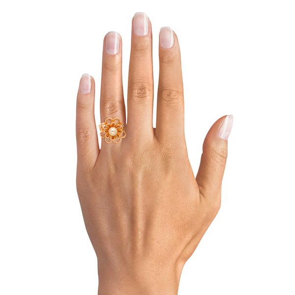 Anillo calado con perla motivo floral en oro amarillo 18 kilates.