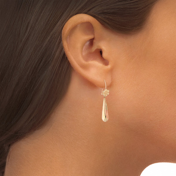 Aretes con colgantes huecos en oro tres tonos 14 kilates.