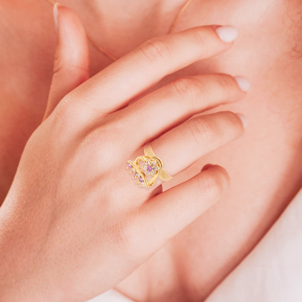 Anillo giratorio motivo floral y corazones con circonias, sintéticos en oro amarillo 14 kilates.