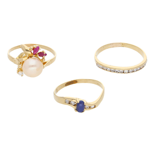Anillo estilizado con perla, sintéticos y dos anillos diseño especial con sintéticos en oro amarillo 14 kilates.