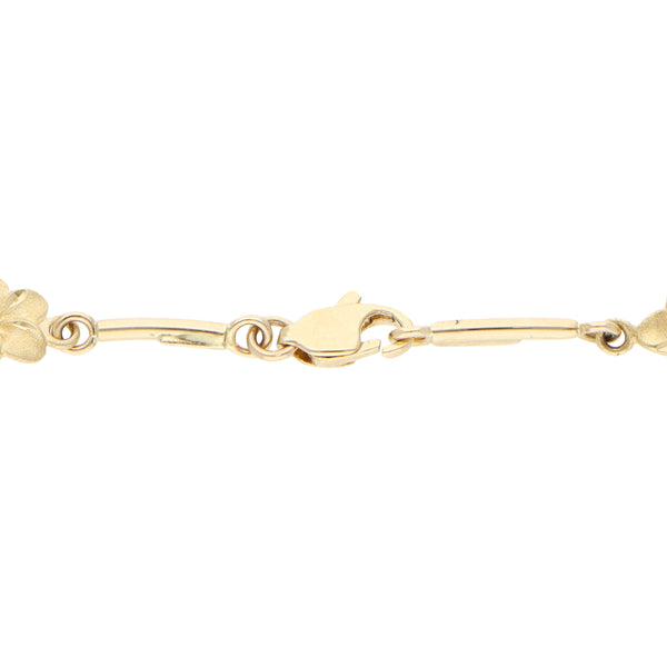 Pulsera eslabón combinado con colgantes motivo catarinas, floral y esmalte en oro amarillo 14 kilates.