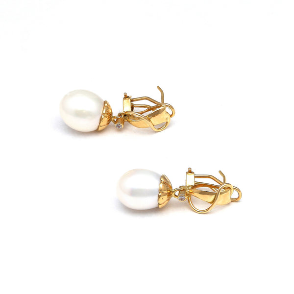 Aretes diseño especial con perla calabazo y circonias en oro amarillo 14 kilates.