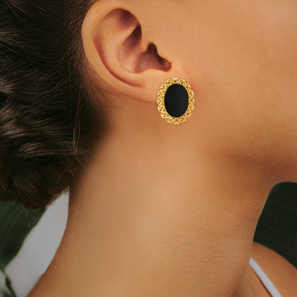 Aretes estilizados calados con ónix en oro amarillo 18 kilates.