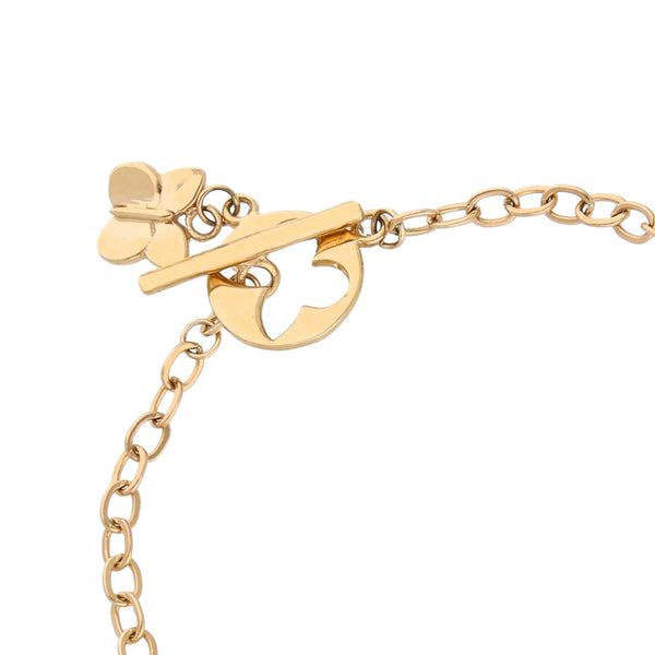 Pulsera eslabón cruzado con dije motivo mariposa en oro amarillo 14 kilates.