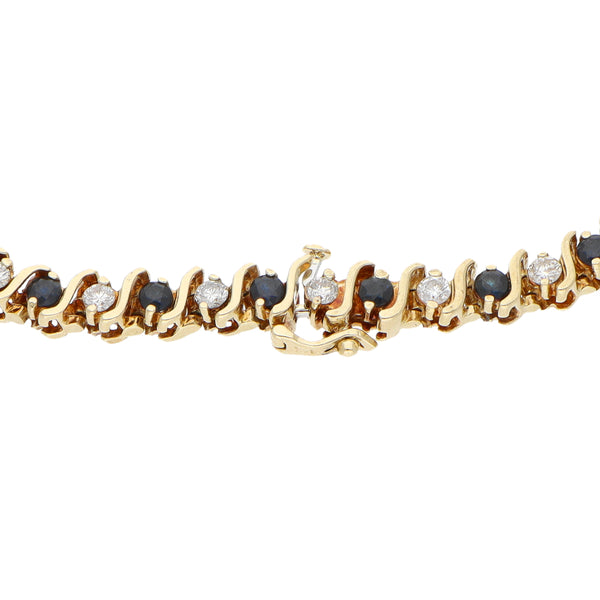 Pulsera eslabón articulado con diamantes y zafiros en oro amarillo 14 kilates.