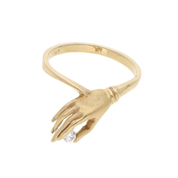 Anillo estilizado motivo mano con circonia en oro amarillo 14 kilates.