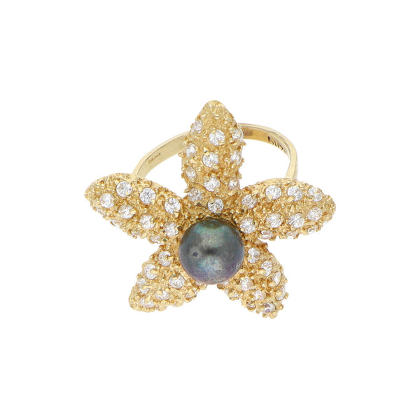 Anillo estilizado motivo estrella de mar con perla y circonias en oro amarillo 14 kilates.