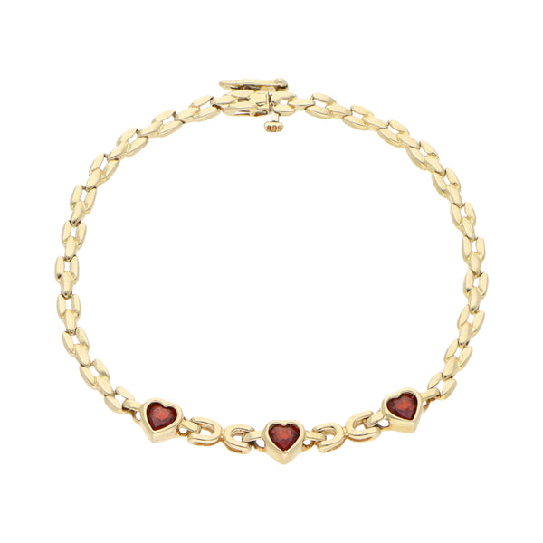 Pulsera eslabón combinado con aplicaciones motivo corazones y granates en oro amarillo 14 kilates.