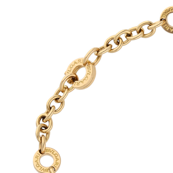 Pulsera eslabón cruzado con aplicaciones, dijes, diamante y ónix firma Bvlgari en oro amarillo 18 kilates.