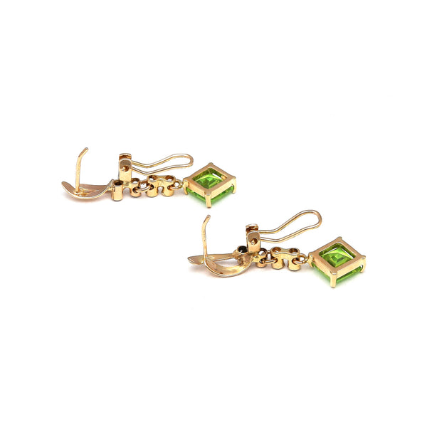 Juego de anillo y aretes estilizados con peridotos y circonias en oro amarillo 14 kilates.