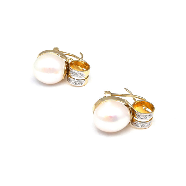 Aretes estilizados con perlas calabazo y diamantes en oro amarillo 14 kilates.