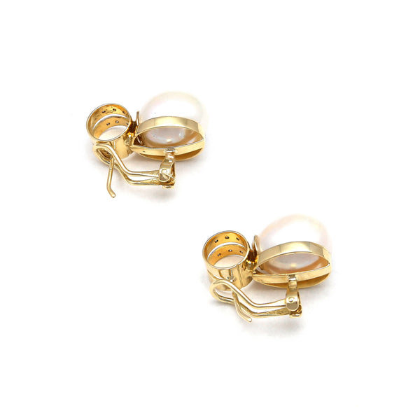 Aretes estilizados con perlas calabazo y diamantes en oro amarillo 14 kilates.