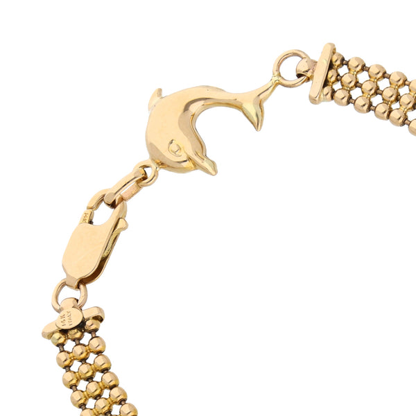 Pulsera eslabón boleado con aplicación motivo delfín en oro amarillo 14 kilates.