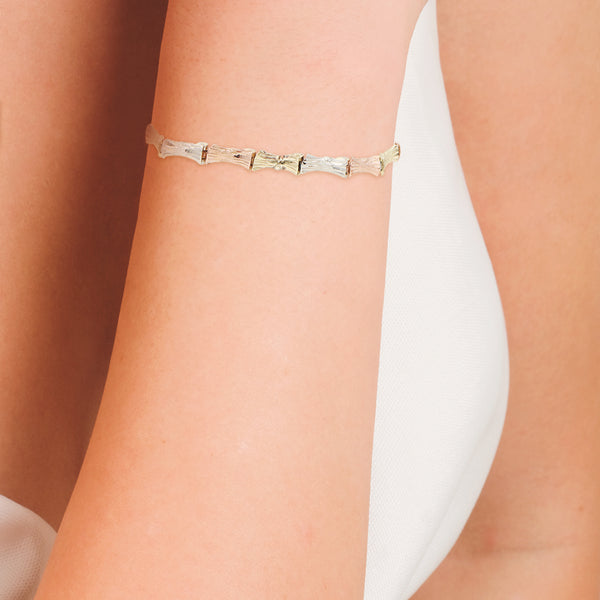 Pulsera eslabón articulado en oro tres tonos 14 kilates.