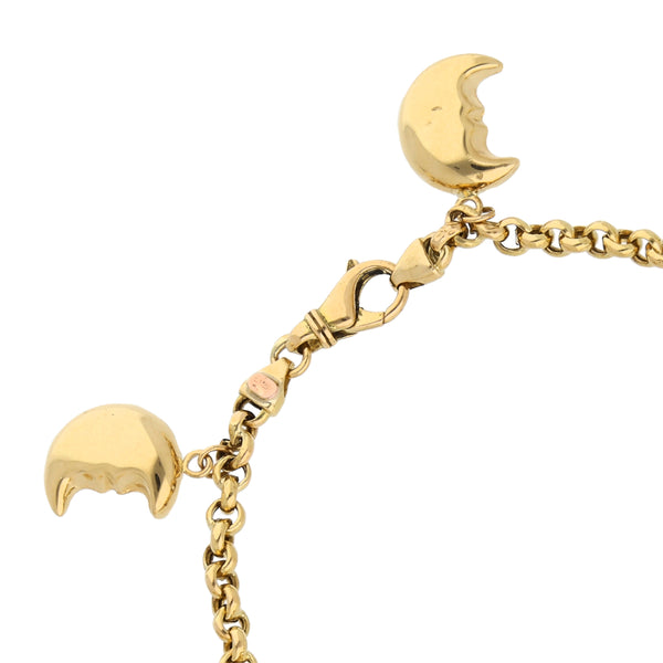 Pulsera eslabón cruzado con colgantes motivo estrella, luna y corazón en oro dos tonos 18 kilates.