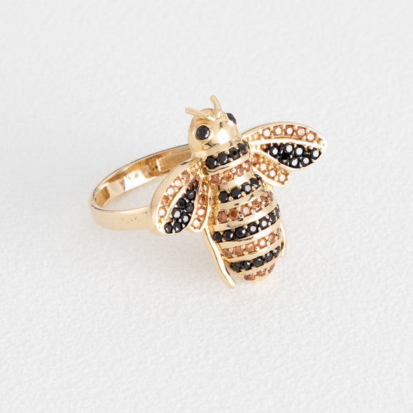 Anillo estilizado motivo abeja con sintéticos en oro amarillo 14 kilates.