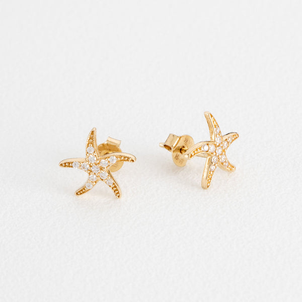 Broqueles diseño especial motivo estrella de mar con circonias en oro amarillo 14 kilates.