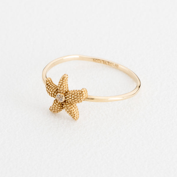 Anillo diseño especial motivo estrella de mar con circonia en oro amarillo 14 kilates.