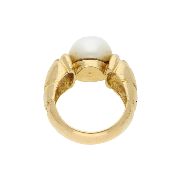 Anillo estilizado con perla en oro amarillo 18 kilates.