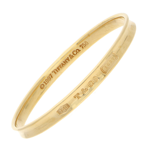 Pulsera de arillo ovalada lisa firma Tiffany & Co. en oro amarillo 18 kilates.